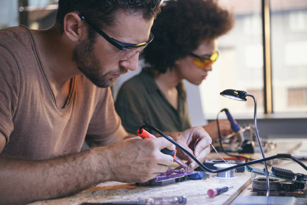 istock Co-workers working late on a circuit boards in office 1213734172