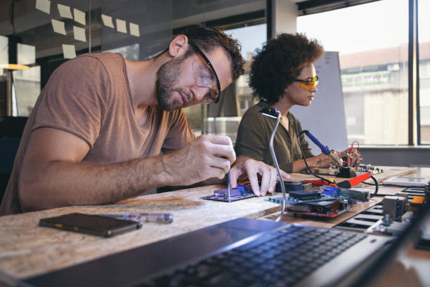 istock Co-workers working late on a circuit boards in office 1213734231
