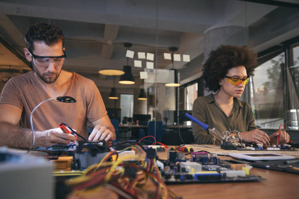 istock Co-workers working late on a circuit boards in office 1213734273