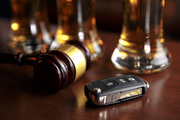 istock Drinking and driving concept. Car key on a wooden table, pub 1213736153