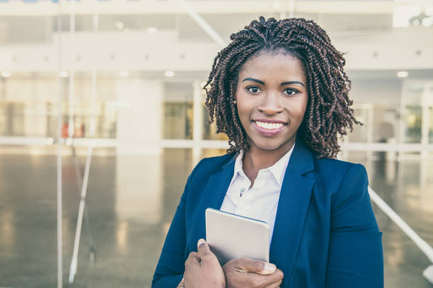 istock Happy employee with tablet posing near office building 1213736949