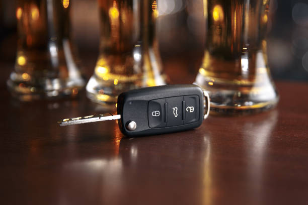 Drinking and driving concept. Car key on a wooden table, pub Drinking and driving concept. Car key on a wooden table, pub background car keys table stock pictures, royalty-free photos & images