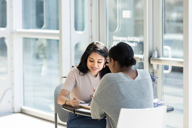 istock Female university students meet in building lobby to study 1213739121