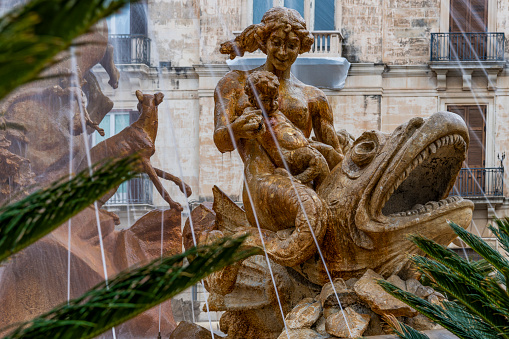 Close view of the sculpture of nymph with baby, as part of the fountain Diana in the center of the square Archimede in Ortigia island in province of Syracuse in Sicily