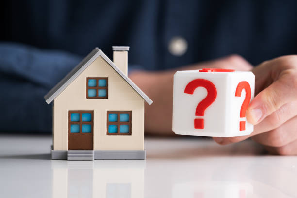 istock Man Holding Question Mark Next To House Model 1213740796