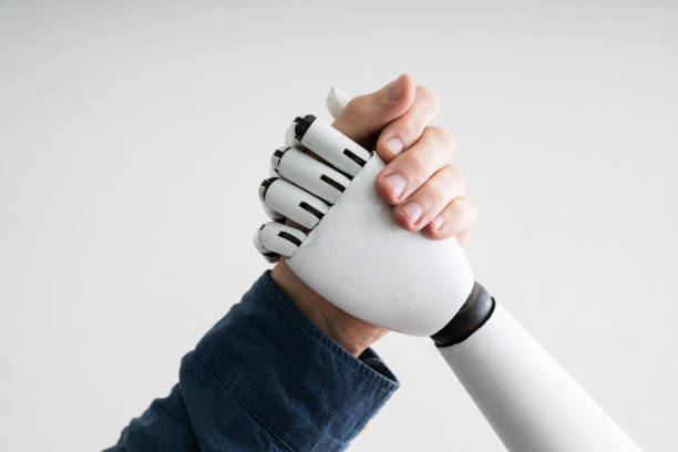 Businessperson And Robot Shaking Hands Close-up Of Businessperson Shaking Hands With Robot robot stock pictures, royalty-free photos & images