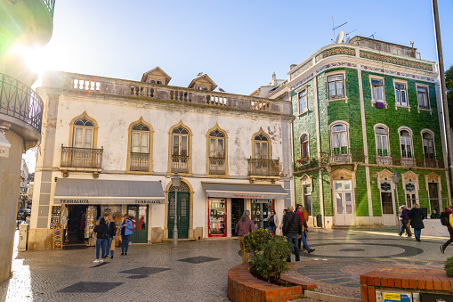 This pic shows famous Praca Luis de Camoes square in Lagos old town in Portugal. Normal tourists and people can be seen in the old town square and pic is taken in january 2020 in lagos city portugal.