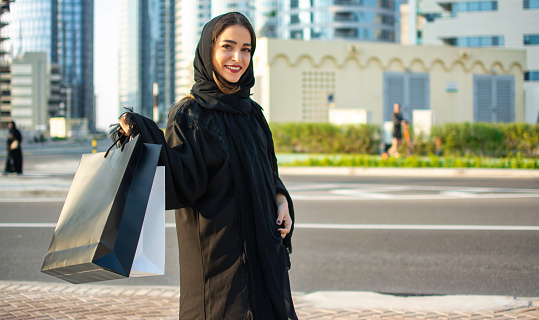 Hermosa mujer de Oriente Medio con bolsas de compras al aire libre photo