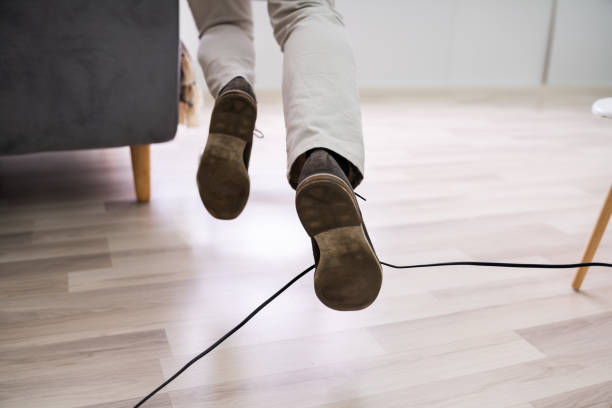 istock Man Legs Stumbling With An Electrical Cord 1213744252