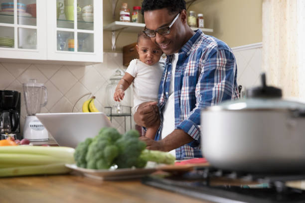istock Father working from home holding baby 1213744625