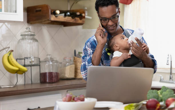 istock Father working from home holding baby 1213744656