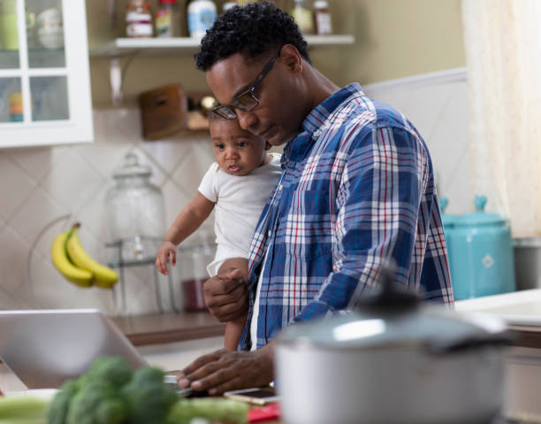 istock Father working from home holding baby 1213744846