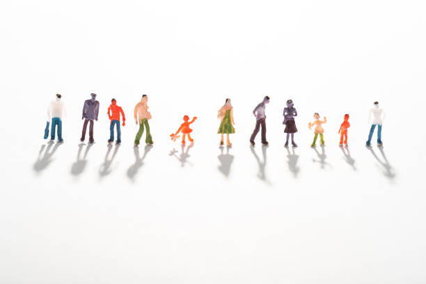 istock Close up view of row of people figures on white surface with shadow 1213745230