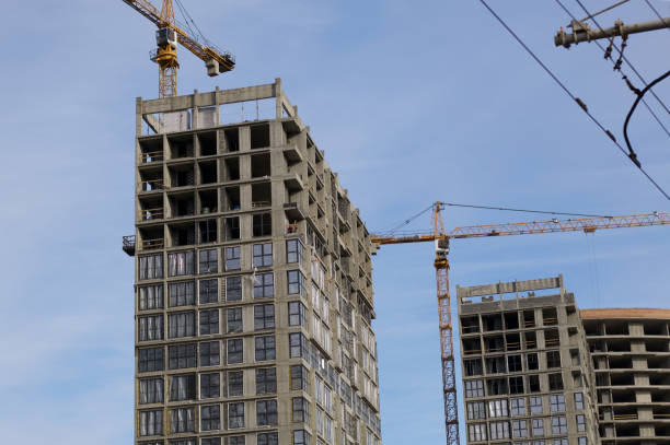istock High-rise building under construction. Reinforced concrete frame. Start of installation of double-glazed windows. Visible construction cranes. 1213746048