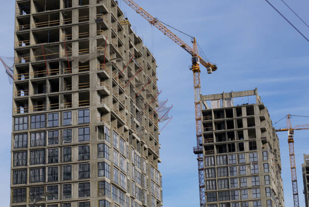 istock High-rise building under construction. Reinforced concrete frame. Start of installation of double-glazed windows. Visible construction cranes. 1213746052