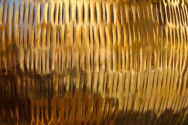 Close up background texture of shiny golden metal surface with chiseled embossing