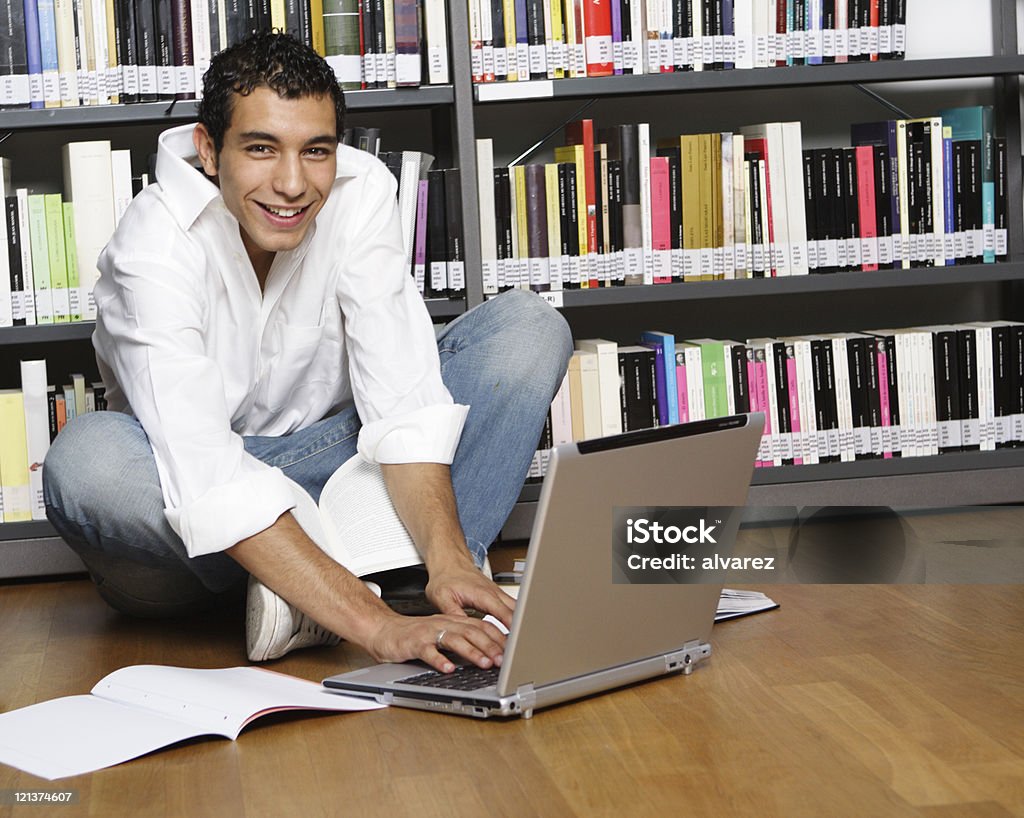 Jeune homme assis avec un ordinateur portable - Photo de 20-24 ans libre de droits