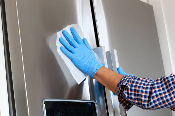 istock Man Cleaning Refrigerator With Disinfectant Wipe 1213746399