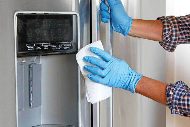 istock Man Cleaning Refrigerator With Disinfectant Wipe 1213746471
