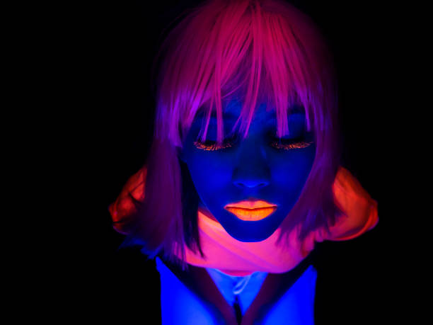 Woman with neon makeup in studio. Close up of female face with fluorescent make up.