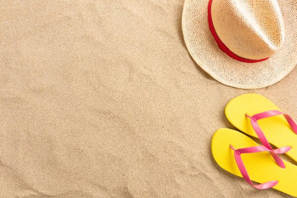 istock Flip flops, straw hat, on sand background. Beach vacation concept .Top view with copy space. 1213754853