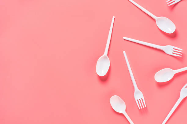 istock White disposable spoons and forks scattered on pink background. Concept of save environment, ecology, recreation on picnic, party and other events. Top view. Copy space 1213757979