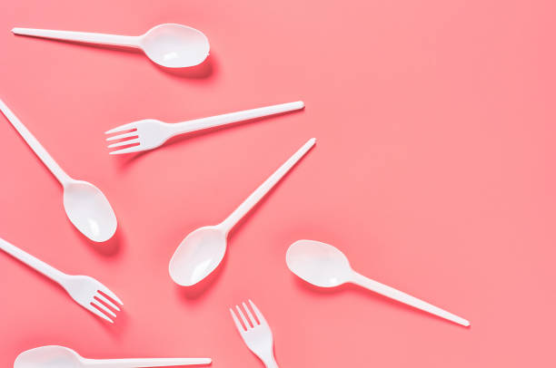istock White disposable spoons and forks scattered on pink background. Concept of save environment, ecology, recreation on picnic, party and other events. Top view. Copy space 1213757981