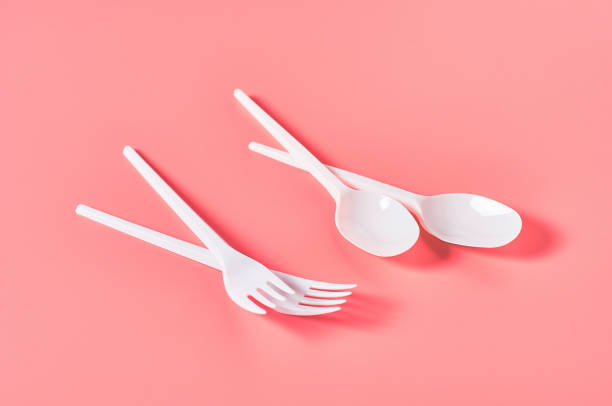 istock White disposable spoons and forks on pink background. Concept of save environment, ecology, recreation on picnic, party and other events 1213757984