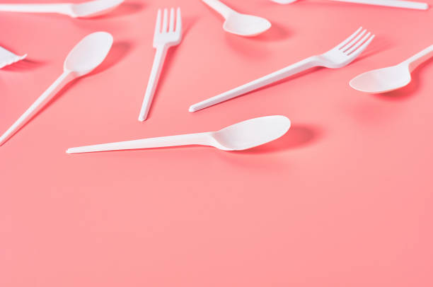 istock White disposable spoons and forks scattered on pink background. Concept of save environment, ecology, recreation on picnic, party and other events. Copy space 1213757985