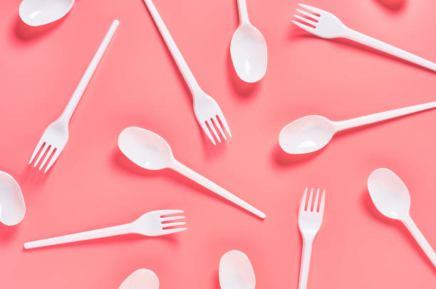 istock White disposable spoons and forks scattered on pink background. Concept of save environment, ecology, recreation on picnic, party and other events. Top view 1213757986