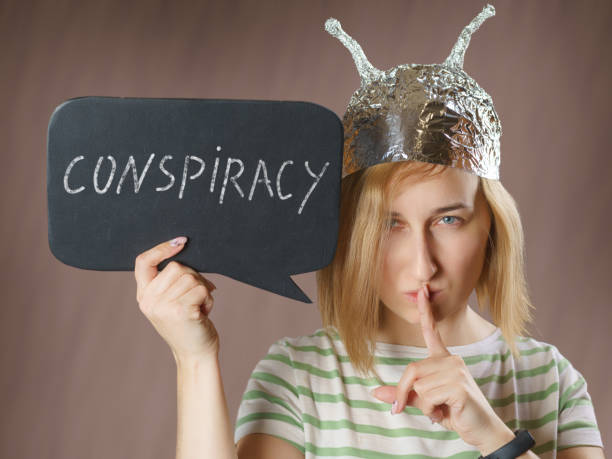 girl in a foil hat with a sign saying conspiracy - tin foil hat imagens e fotografias de stock