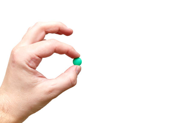 istock hand holds one tablet in fingers 1213761689