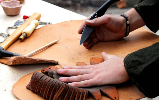 A professional re-enactment craftsman making leather shoes like how it was done in the past stock photo