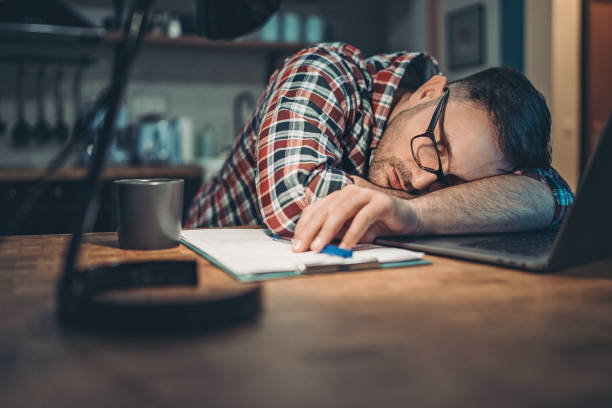 istock Overworked man fallen asleep on the desk 1213764567