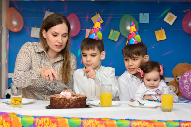 istock Mom cuts a birthday cake with her children 1213765361