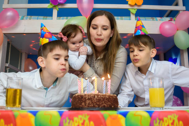 istock Family blowing candles on birthday cake 1213765369