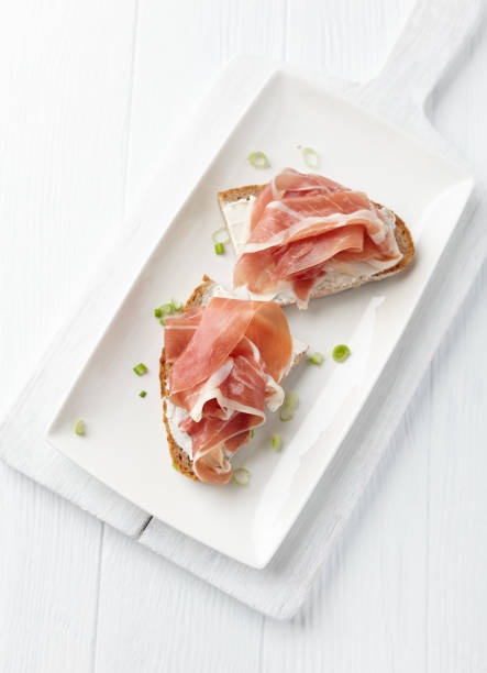 istock Sandwich with soft cheese and ham. Bright wooden background. 1213765931