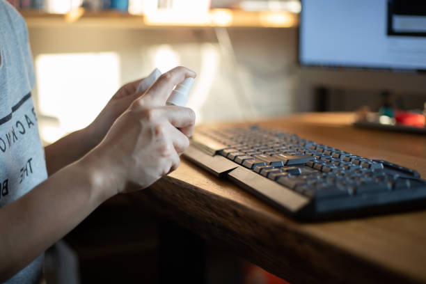 istock Close up of Women hands using alcohol spray and wiping down surfaces on a computer keyboard for cleaning and protect COVID-19 1213766479