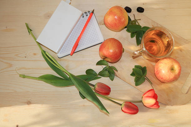 istock Home office and remote work, Apple juice and notepad on a wooden table. The concept of detoxification, diet and weight loss, natural nutrition, increasing the body's immune defense against viruses 1213768360