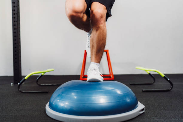 istock Man legs - training balance on bosu ball in functional gym 1213768842