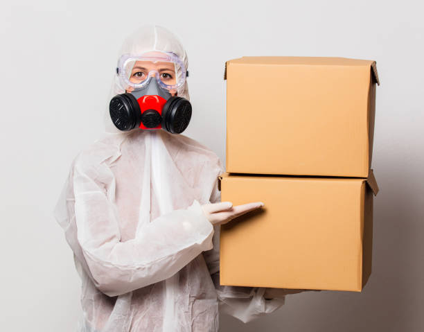 istock postman in protection suit and glasses with mask holds delivery boxes 1213770963