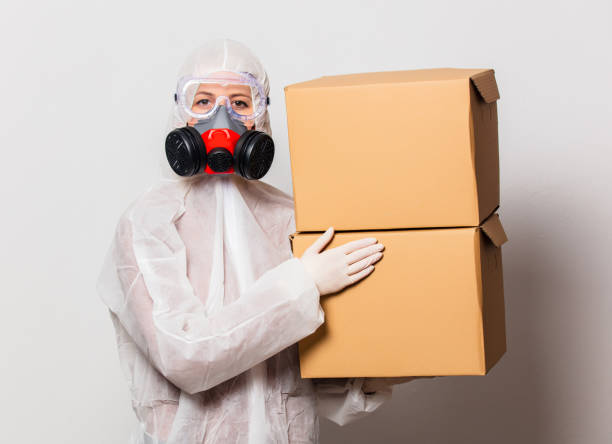 istock postman in protection suit and glasses with mask holds delivery boxes 1213771006