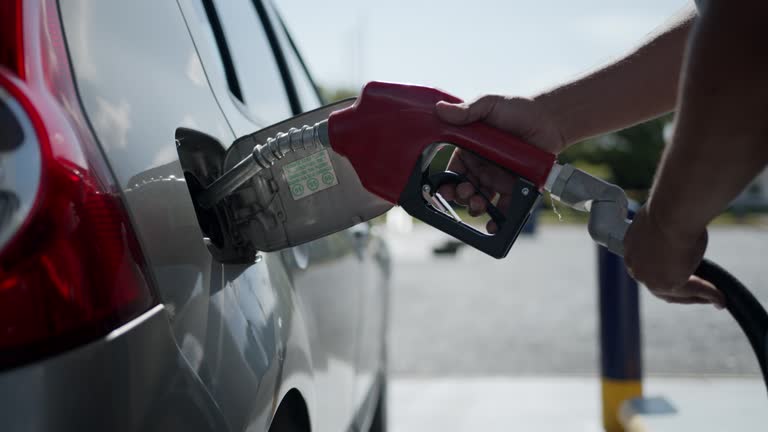 Unrecognizable man refueling a tank at a gas station