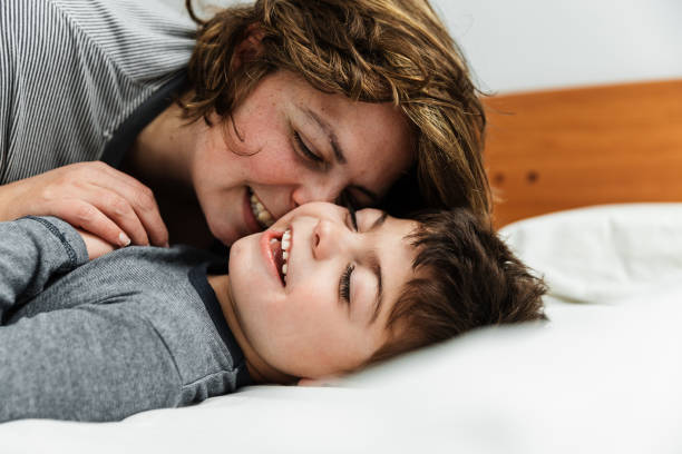 istock mother and son playing in bed, having fun. 1213771705