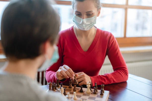 istock Mother and kid during coronavirus crisis playing chess at home 1213773201