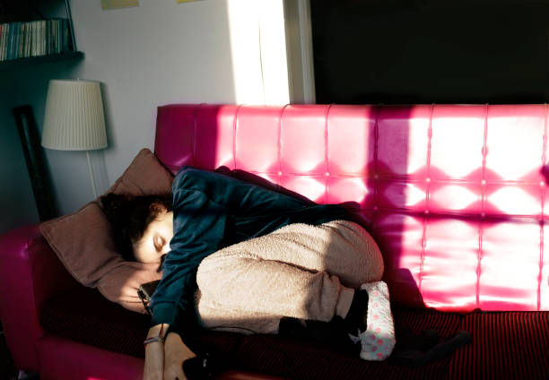 istock teenage girl napping on a red sofa 1213773222
