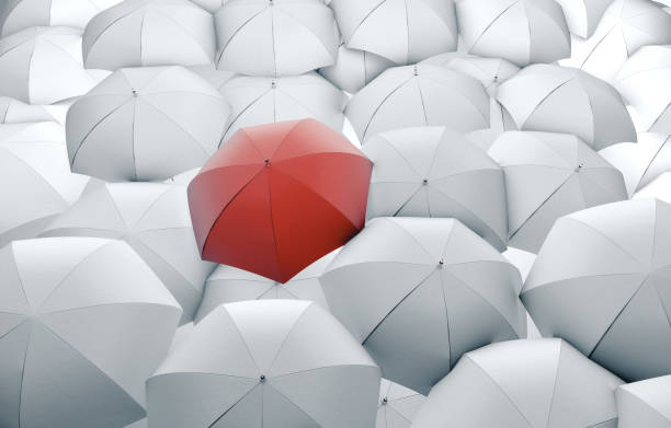 istock Red umbrella in mass of white umbrellas 1213777324