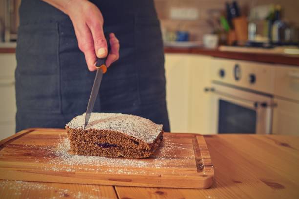 Man cutting classic gingerbread in traditional kitchen. A classic gingerbread recipe Family home bakery, cooking traditional festive sweets.