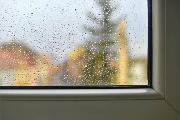istock Blurred view on a rainy day through the window. Raindrops on the glass window. 1213779429