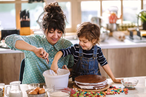 パーティーのためのバースデーケーキを作る - cake birthday domestic kitchen child ストックフォトと画像